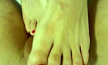 Close-up da namorada fazendo massagem nos pés e acariciando um pau grande
