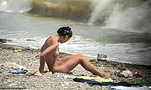 黑发裸体女孩在海滩上裸体走动