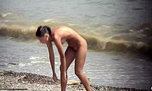 Mörkhårig nakenbrud går runt naken på en strand