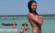 Une brune plantureuse avec un corps génial montre son bronzage sur une plage