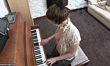 Leken brunette med muntre pupper spiller piano toppløs