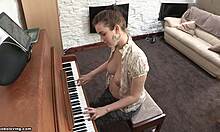 Morena brincalhona com seios empinados tocando piano sem blusa