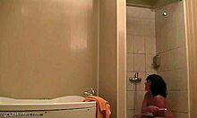 Ohromujúca žena relaxuje pod sprchou a je sledovaná