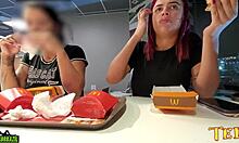Two sexually aroused women have their breasts exposed while dining at McDonald's - featuring a professionally inked angel