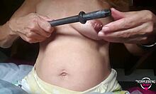 Mama perversă cu piercing-uri întinse pe sfârcuri se bucură de o inserție de tijă de 16 mm într-un videoclip făcut acasă