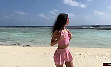 Zlatý déšť na pláži na Maledivách pro krásnou dívku, která močí