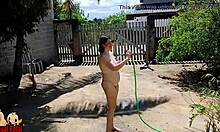 Nudistická žena v domácnosti sa kúpe na prednom dvore