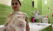 En gravid tonåring med stora bröst och sexig rumpa tar ett bad